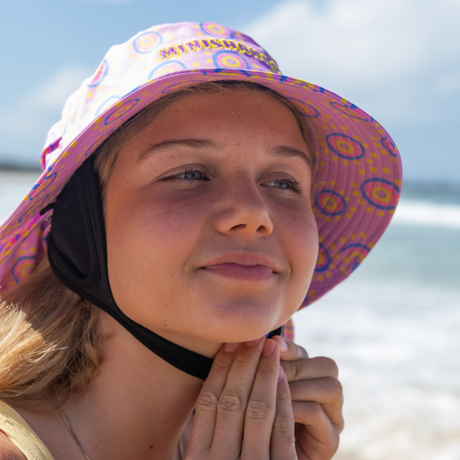 Woman wearing a colorful sun surf hat on a beach