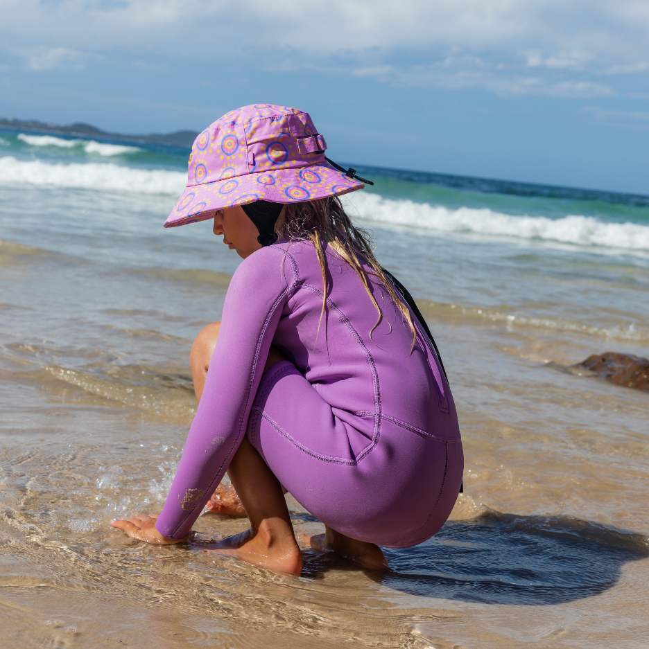 Girl wearing plow surf co surf hat designed by Leihani Zoric Indigenous Australian artist and surfer to support her surfing goals